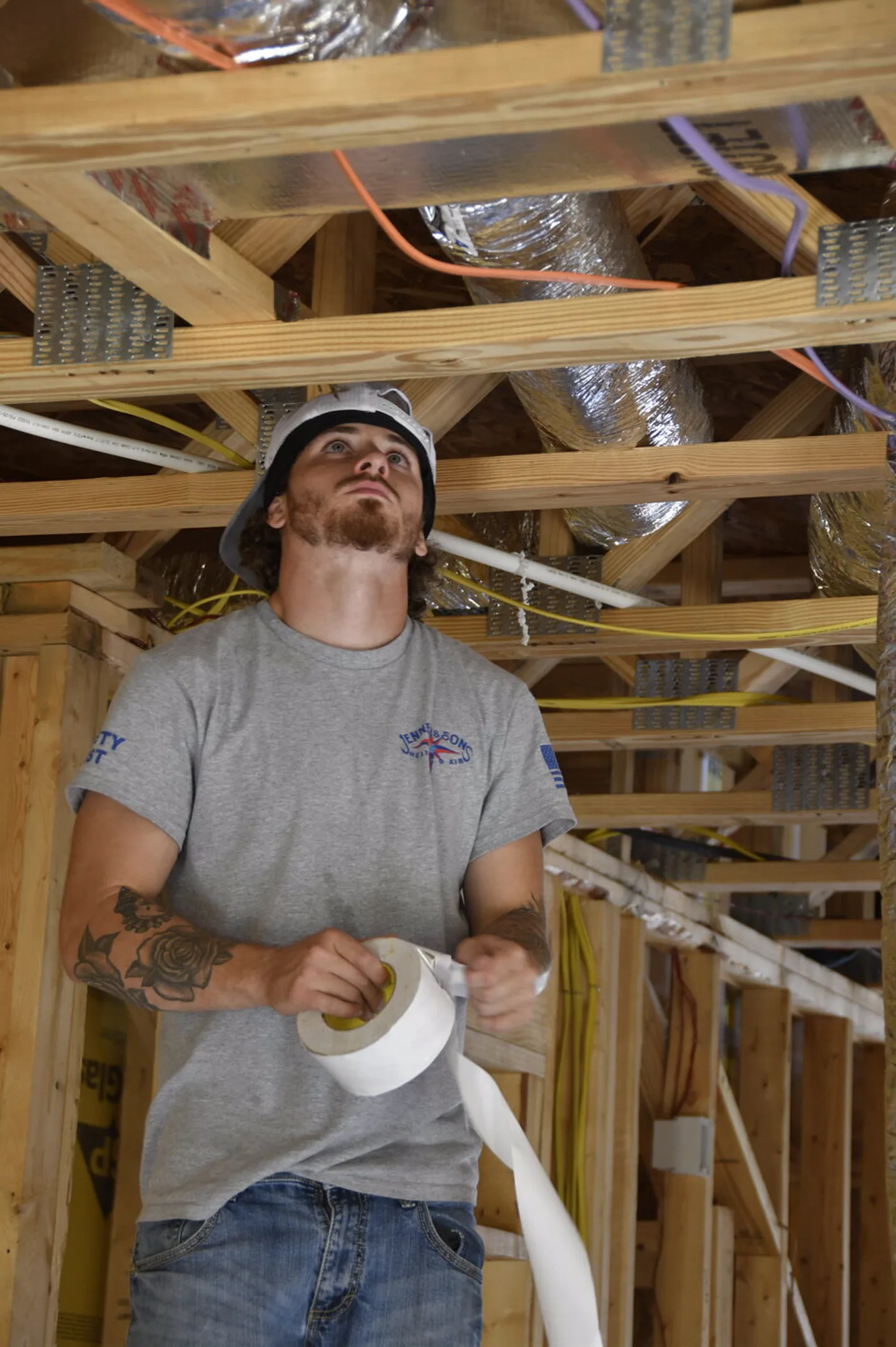 Technician sealing ductwork with foil tape
